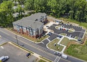 Thumbnail 2 of 31 - An aerial view of a parking lot and a building with a red brick exterior.
