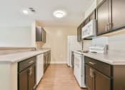 Thumbnail 12 of 29 - a kitchen with dark cabinets and white appliances
