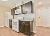Thumbnail 7 of 29 - a kitchen with dark cabinets and white appliances