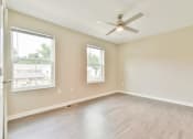 Thumbnail 10 of 29 - an empty bedroom with a ceiling fan and two windows