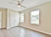 Thumbnail 26 of 29 - an empty bedroom with a ceiling fan and two windows