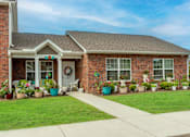 Thumbnail 4 of 27 - a house with a lawn and potted plants in front of it