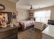 Thumbnail 6 of 27 - a bedroom with a bed and a dresser
