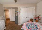 Thumbnail 12 of 27 - a bedroom with a bed and a dresser
