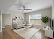 Thumbnail 39 of 39 - A living room with a grey couch, a coffee table, and a ceiling fan.