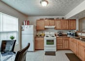 Thumbnail 16 of 20 - A kitchen with wooden cabinets and a white refrigerator.