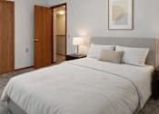 Thumbnail 18 of 20 - A bedroom with a large bed and a painting on the wall.
