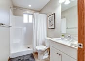 Thumbnail 28 of 28 - A white bathroom with a toilet, sink, and shower.