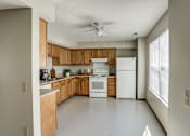 Thumbnail 30 of 30 - A kitchen with wooden cabinets and white appliances.