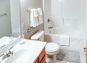 Thumbnail 25 of 28 - A white toilet is in a bathroom with a white sink.