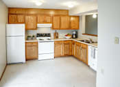 Thumbnail 27 of 28 - A kitchen with wooden cabinets and white appliances.
