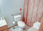 Thumbnail 16 of 17 - A white toilet with a towel rack and a sink in a bathroom.