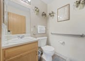Thumbnail 26 of 27 - A white toilet sits next to a sink in a bathroom.