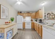 Thumbnail 27 of 27 - A kitchen with wooden cabinets and white appliances.