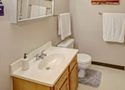 Thumbnail 22 of 23 - A white toilet sits next to a sink in a bathroom.
