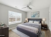 Thumbnail 51 of 52 - A bedroom with a large bed and a ceiling fan.