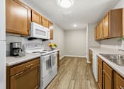 Thumbnail 53 of 53 - A kitchen with wooden cabinets and white appliances.