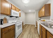 Thumbnail 50 of 52 - A kitchen with wooden cabinets and white appliances.