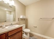 Thumbnail 29 of 32 - A bathroom with a toilet, sink, and mirror.