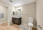 Thumbnail 43 of 45 - A bathroom with a white toilet and a sink with a mirror above it.