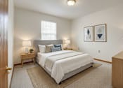 Thumbnail 27 of 29 - A bedroom with a large bed, two nightstands, and a window.