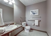 Thumbnail 28 of 29 - A bathroom with a toilet, sink, and towel rack.