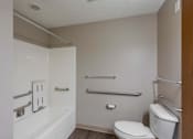 Thumbnail 48 of 83 - A white toilet sits next to a white bathtub in a small bathroom.