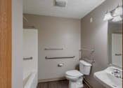 Thumbnail 46 of 83 - A small bathroom with a toilet, sink, and towel racks.