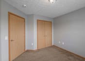 Thumbnail 42 of 83 - A room with two doors and carpeted floor.