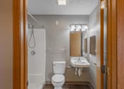 Thumbnail 69 of 83 - A white toilet and sink in a small bathroom.
