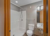 Thumbnail 67 of 83 - A white toilet is in a bathroom with a walk-in shower.