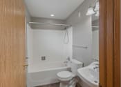 Thumbnail 50 of 83 - A white bathroom with a toilet, sink, and bathtub.