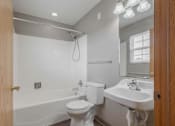 Thumbnail 58 of 83 - A white toilet sits next to a white sink in a bathroom.