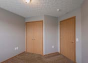 Thumbnail 75 of 83 - Two wooden doors in a room with carpeted floor.