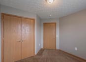 Thumbnail 83 of 83 - A room with two wooden doors and a carpeted floor.