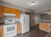 Thumbnail 39 of 83 - A kitchen with white appliances and wooden cabinets.