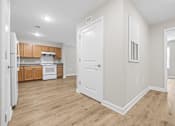 Thumbnail 9 of 31 - A kitchen with wooden floors and white walls.