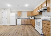 Thumbnail 7 of 31 - A kitchen with white appliances and wooden cabinets.