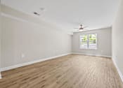 Thumbnail 15 of 31 - Empty room with wooden floor and ceiling fan.