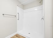 Thumbnail 18 of 31 - A white shower stall with a glass door and a white wall.
