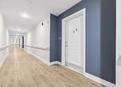 Thumbnail 16 of 31 - A long hallway with a white door on the right.