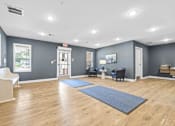 Thumbnail 27 of 31 - A spacious room with wooden floors and a variety of exercise equipment.