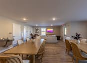 Thumbnail 2 of 55 - A dining room with a long wooden table and chairs.