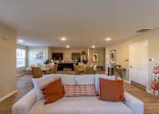 Thumbnail 7 of 55 - A living room with a grey couch and orange pillows.
