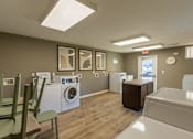 Thumbnail 1 of 55 - A laundry room with a washer and dryer, a washing machine, a cabinet, and a wash basin.