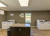 Thumbnail 19 of 55 - A room with a counter and a washing machine.