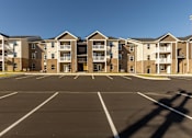 Thumbnail 14 of 55 - A parking lot in front of apartment buildings.