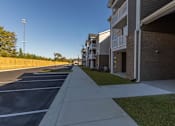 Thumbnail 18 of 55 - A long concrete walkway leads to a row of apartment buildings.