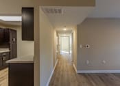 Thumbnail 23 of 55 - A long hallway with wood floors and white walls.