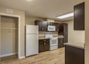 Thumbnail 28 of 55 - A kitchen with white appliances and brown cabinets.